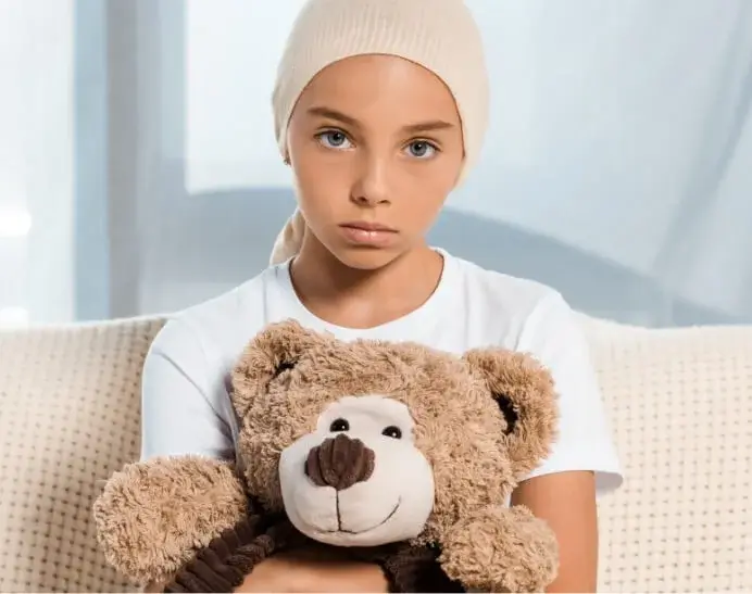 grades of brain tumours can vary. This image shows a young girl with a head bandage looking sad and holding a teddy