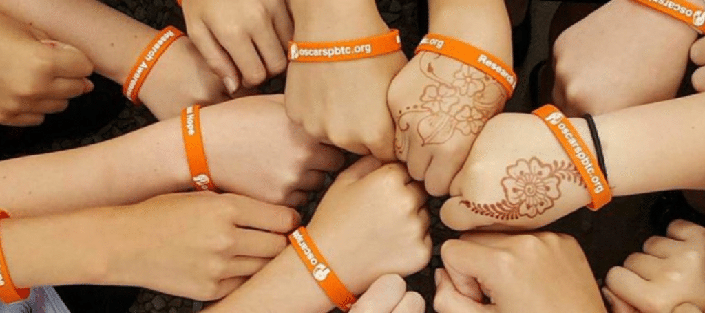 Dartmoor Family Challenge 2 lots of hands as fists all touching wearing wristbands of OSCAR's paediatric brain tumour charity local York Charity Childrens charities