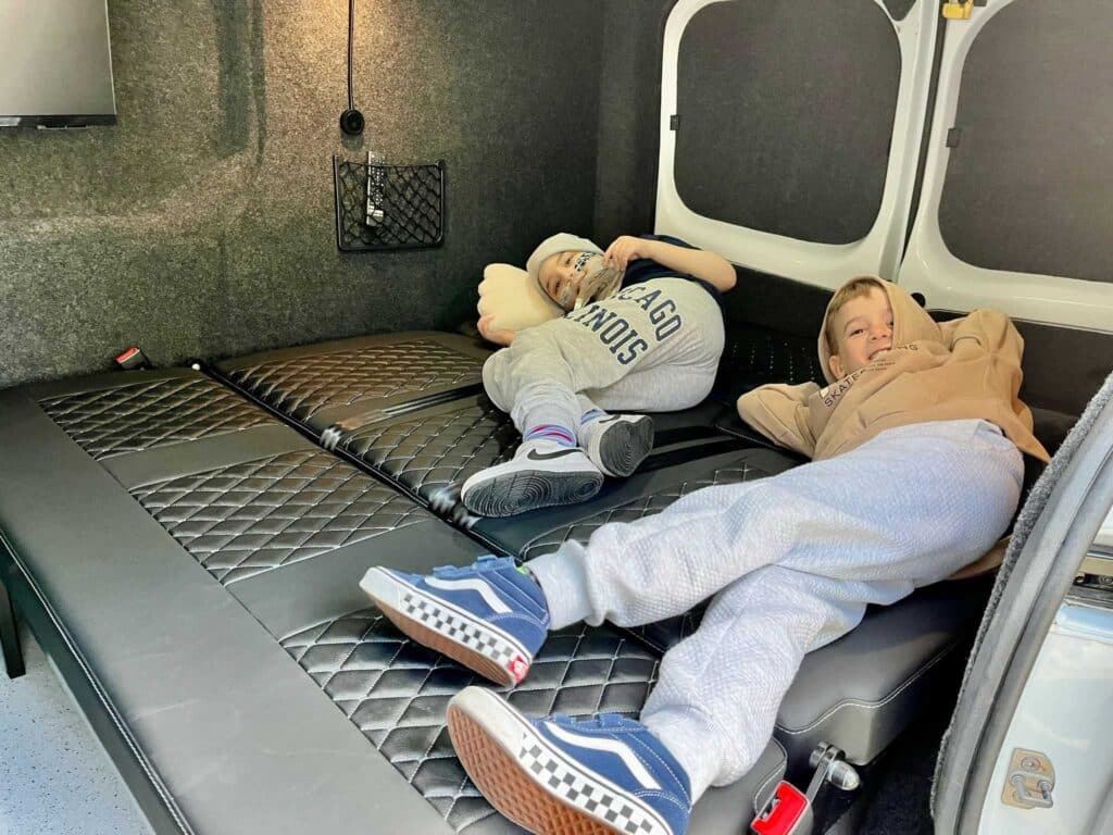 Oliver and Tomos lying down in the back of the van